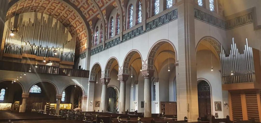 The interior of Pfarrkirche St Antonius in Düsseldorf, showing the west-end gallery organ an east-end choir organ.