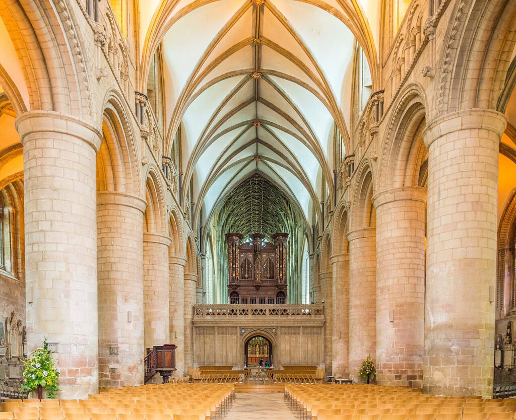 A view looking East down the Nave of Gloucester Cathedral, showing the organ on the Rood screen