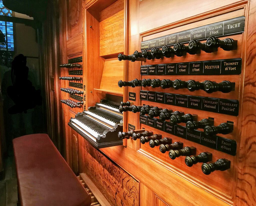 The console of the organ in the Oude Kerk, Amsterdam, with three keyboards and many rows of stop knobs.