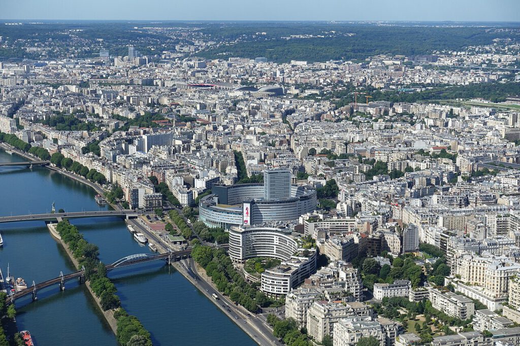 An aerial view of Paris showing the River Seine and the Maison de la Radio et de la Musique with its distinctive 'round house' design.