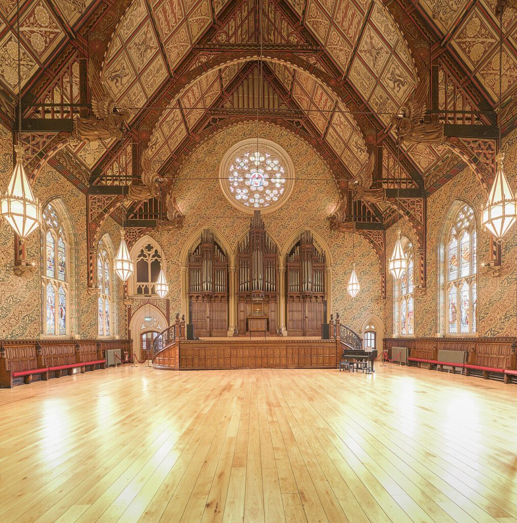 The interior of the Great Hall in Rochdale Town Hall, showing the Binns organ filling three arches beneath the rose window.