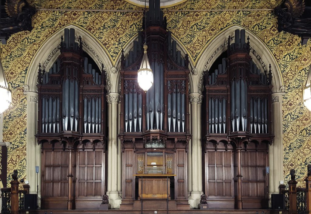 Front-view of the Binns organ in the Great Hall of Rochdale Town Hall, showing ornate carved woodwork and pipes filling three arches.